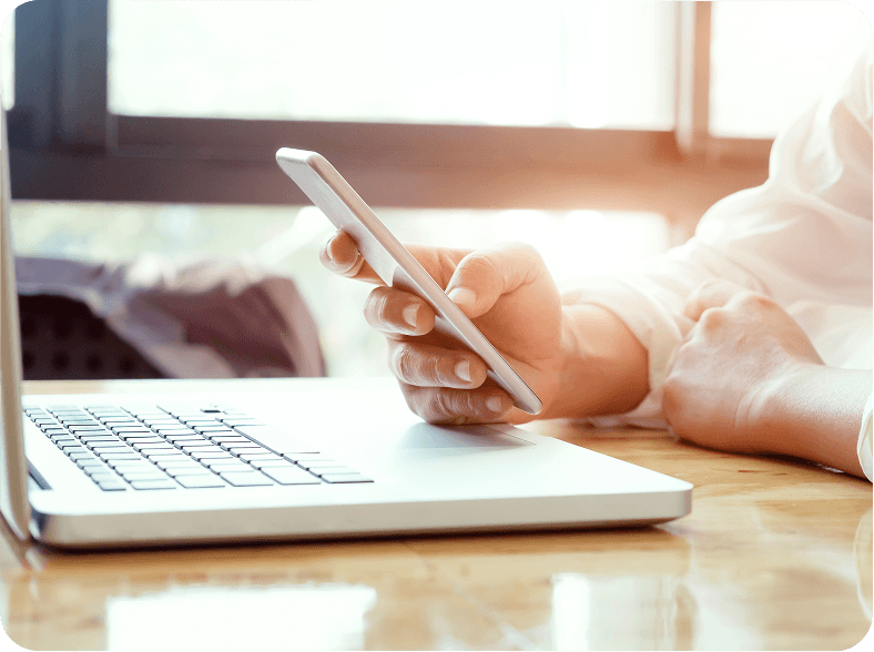 Pessoa utilizando laptop e smartphone